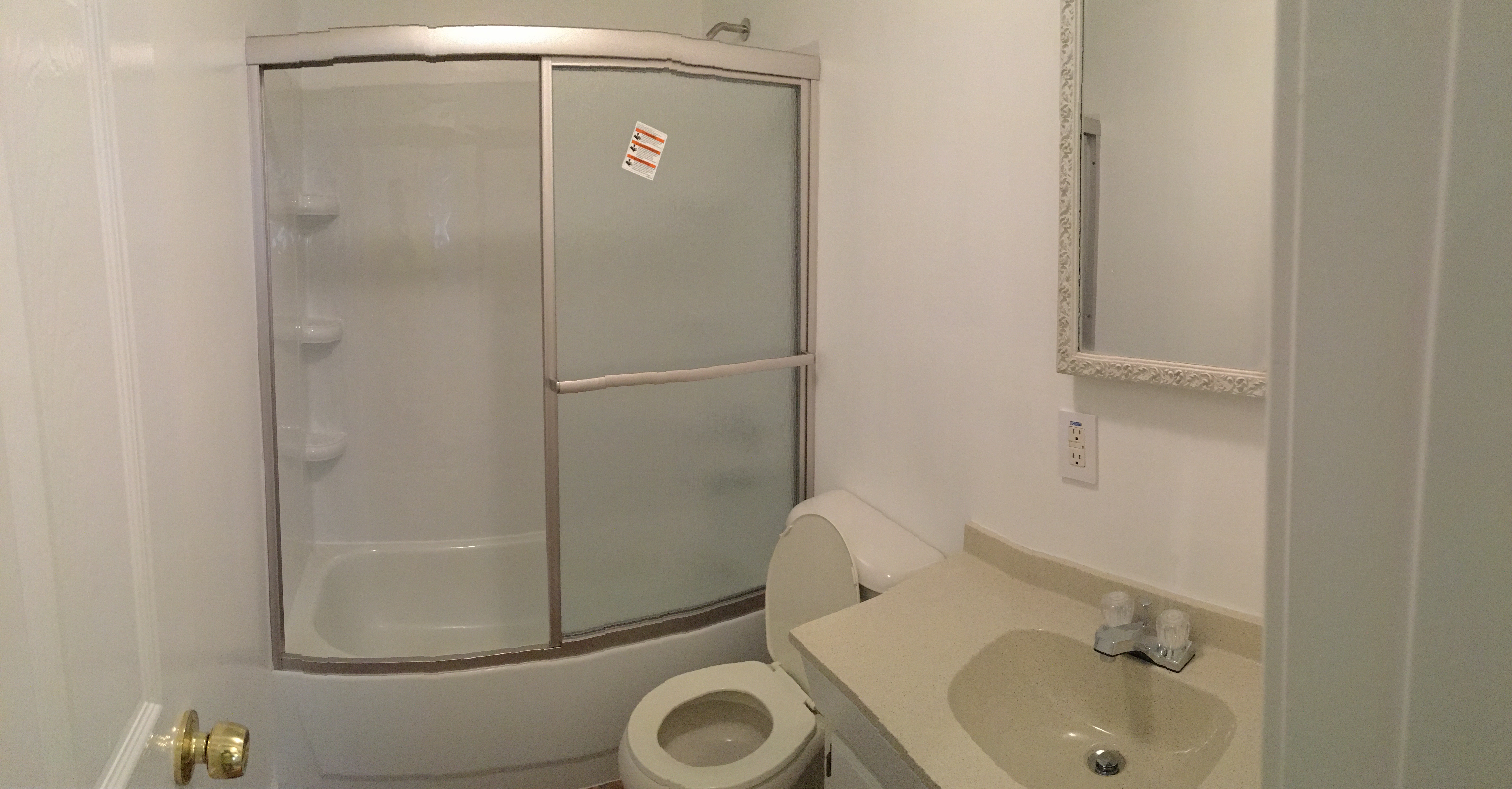 Bathroom before remodel — original tub surround and vanity
