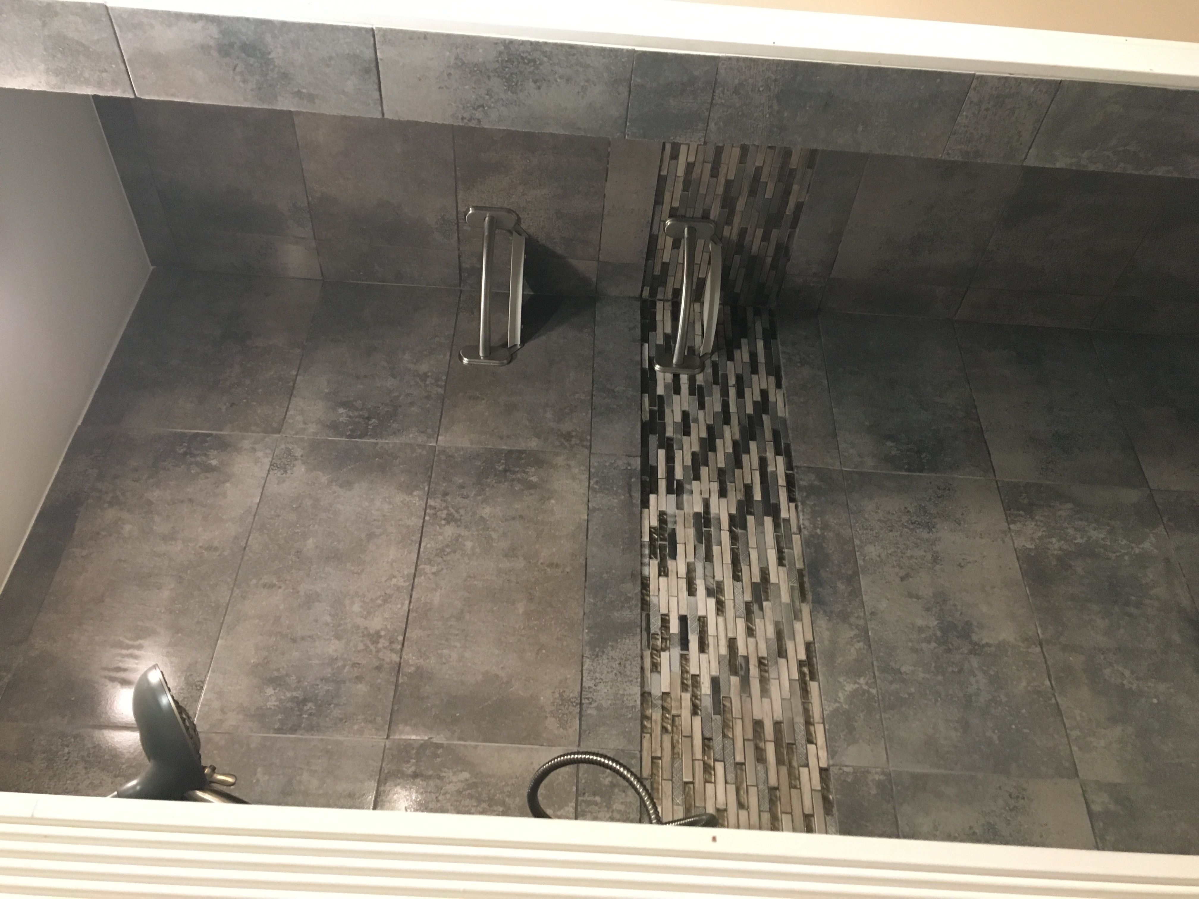 Bathroom after remodel — custom tile shower floor with mosaic accent strip